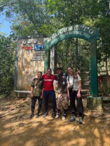 Travelers and local jungle guides at the entrance of Gunung Leuser National Park before starting a Bukit Lawang jungle trek in North Sumatra, Indonesia